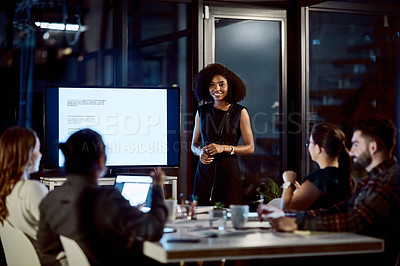 Buy stock photo Shot of a young businesswoman delivering a presentation during a late night meeting at work