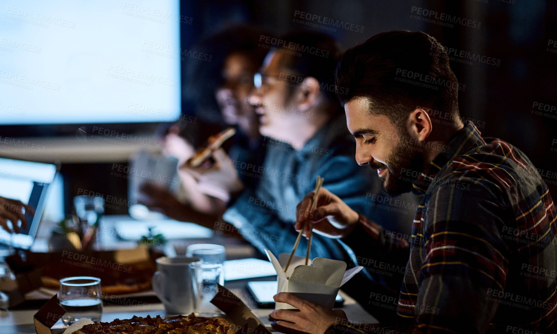 Buy stock photo Eating, night and business man in office meeting, Chinese food and creative employee on work break. Hungry team, takeout and dinner in evening at workplace, startup and happy person on overtime