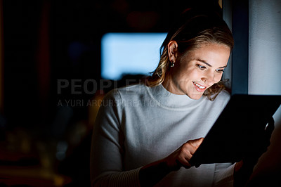 Buy stock photo Shot of a young businesswoman using a digital tablet during a late night at work