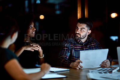Buy stock photo Shot of a group of young businesspeople having a late night meeting at work