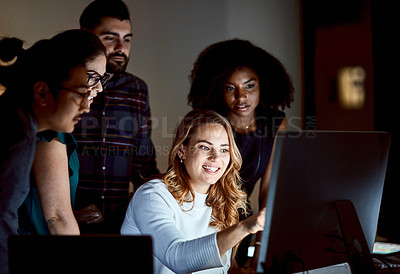 Buy stock photo Shot of a group of young businesspeople using a computer during a late night at work
