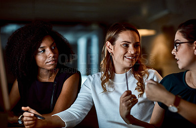 Buy stock photo Shot of a group of young businesswomen having a discussion during a late night at work