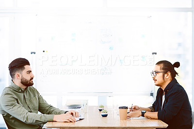 Buy stock photo Shot of two young businessmen having a meeting in a modern office