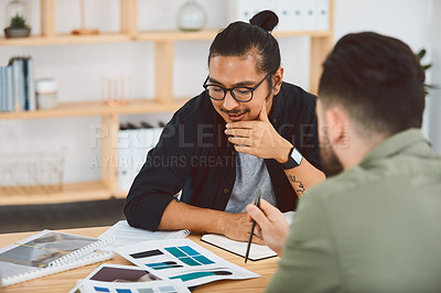 Buy stock photo Shot of two young businessmen having a meeting in a modern office