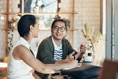 Buy stock photo Shot of young business partners sitting and talking with each other in a coffee shop during the day