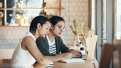 Buy stock photo Shot of young business partners sitting and working with each other in a coffee shop during the day