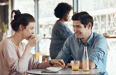 Buy stock photo Shot of an affectionate young couple sitting with each other in a coffee shop during the day