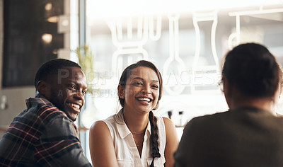 Buy stock photo Shot of a happy young diverse group sitting together in a coffee shop during the day