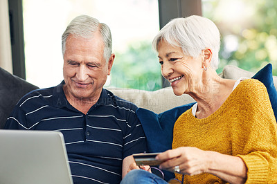 Buy stock photo Shot of a senior couple using a credit card and laptop on the sofa at home
