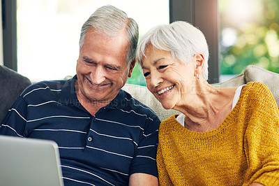 Buy stock photo Shot of a senior couple using a laptop on the sofa at home