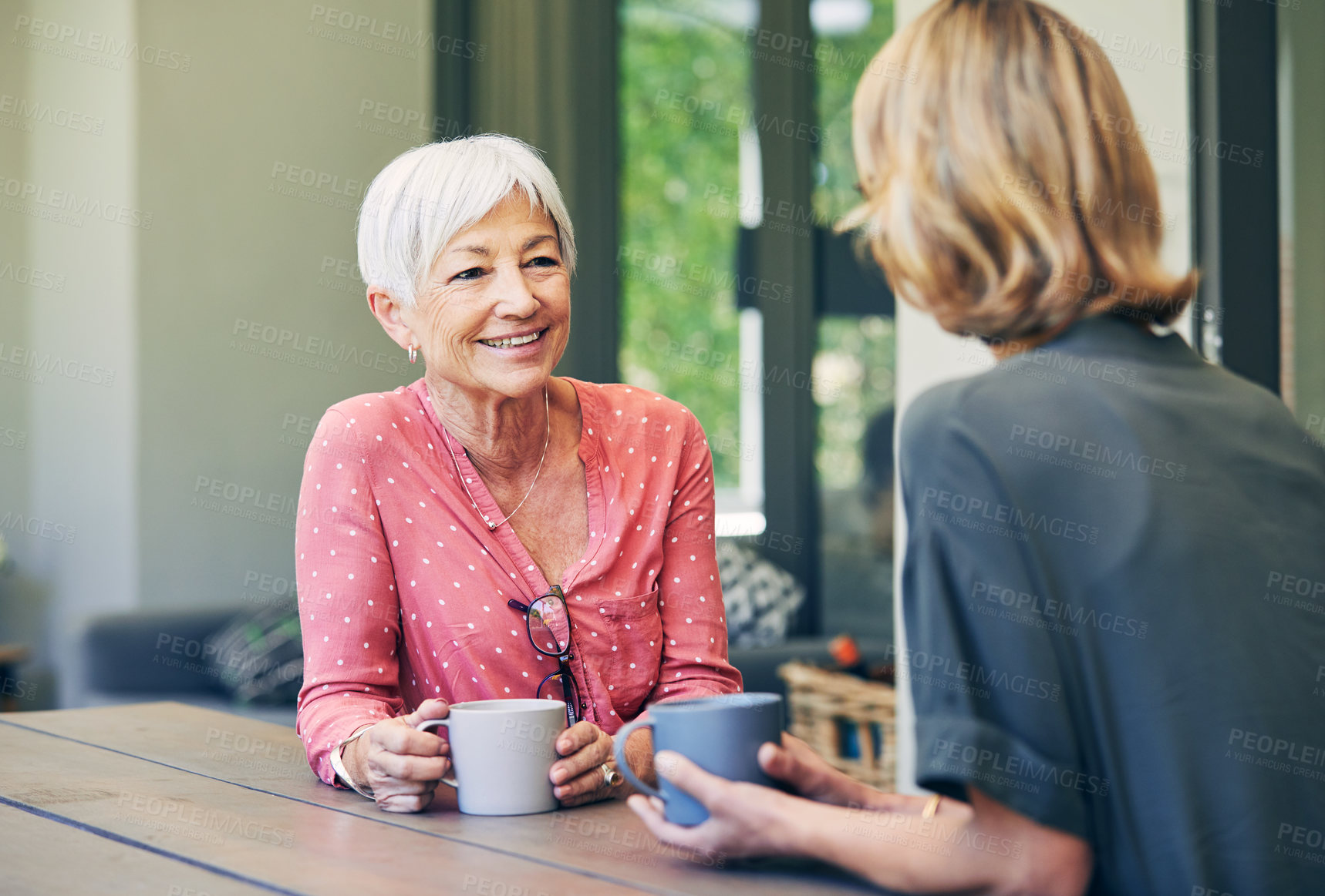 Buy stock photo Shot of a mature woman and her elderly mother having coffee and a chat at home