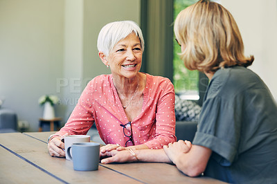 Buy stock photo Shot of a mature woman and her elderly mother having coffee and a chat at home