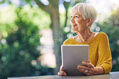 Buy stock photo Shot of a senior woman using a digital tablet in her backyard