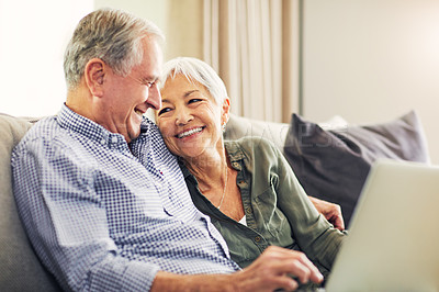 Buy stock photo Shot of a senior couple using a laptop on the sofa at home