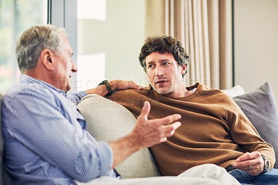 Buy stock photo Shot of a mature man and his elderly father sitting on the sofa at home and chatting