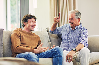 Buy stock photo Shot of a mature man and his elderly father sitting on the sofa at home and chatting