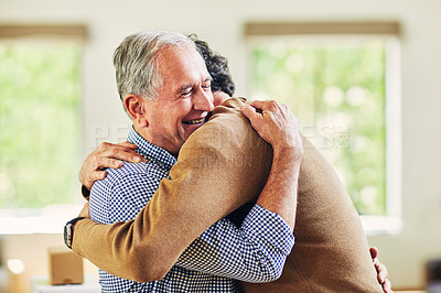 Buy stock photo Shot of a mature man and his elderly father embracing each other at home