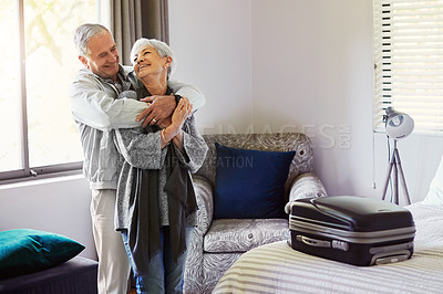 Buy stock photo Shot of a happy senior couple embracing in their hotel room