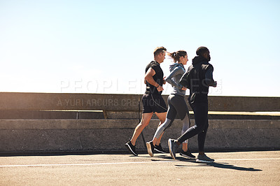 Buy stock photo Shot of a group of sporty young people out exercising together