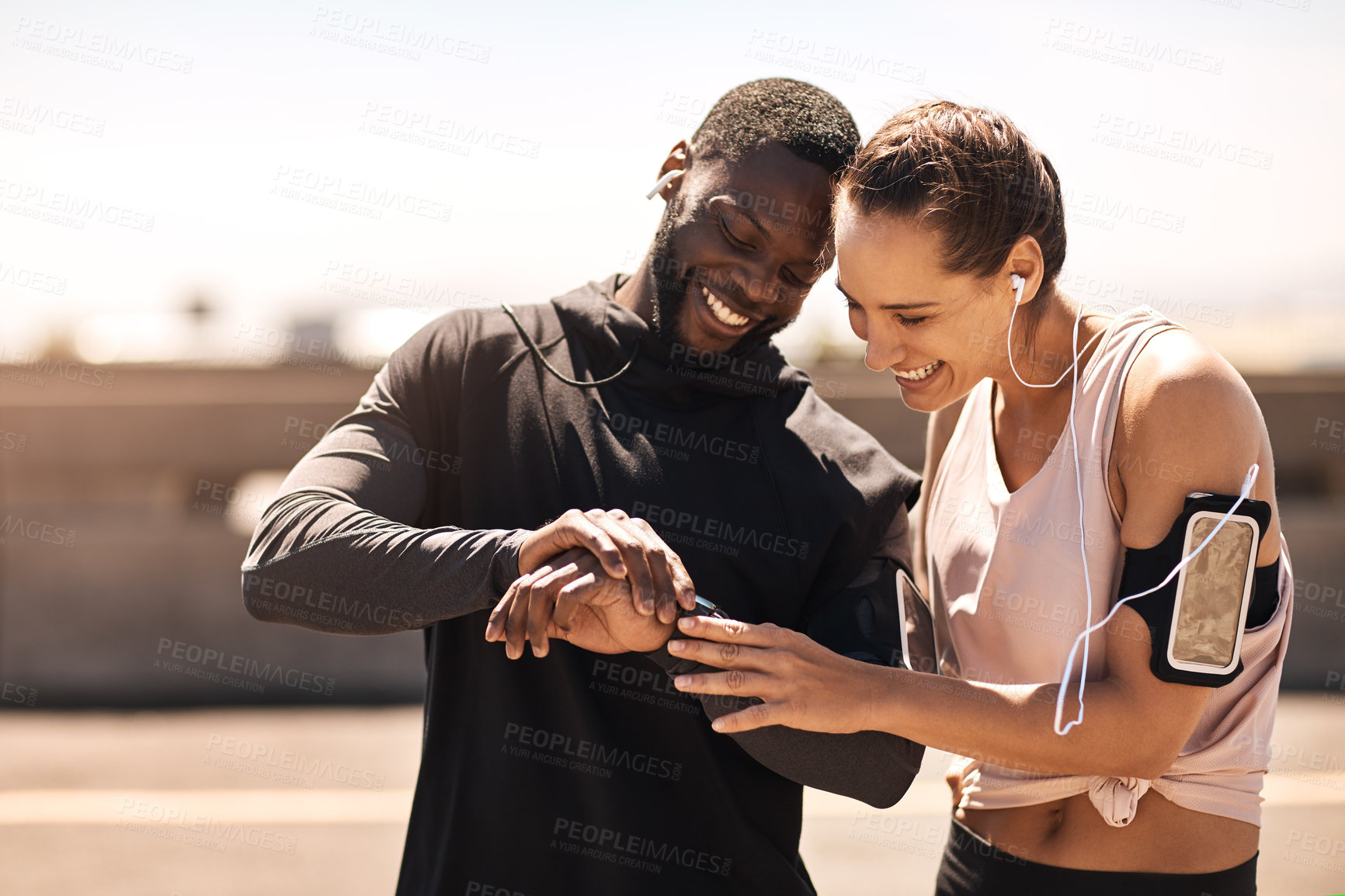 Buy stock photo Shot of two sporty young people checking the stopwatch after a run