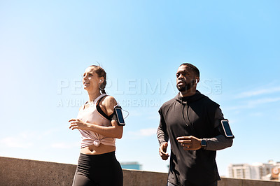 Buy stock photo Shot of two sporty young people out for a run