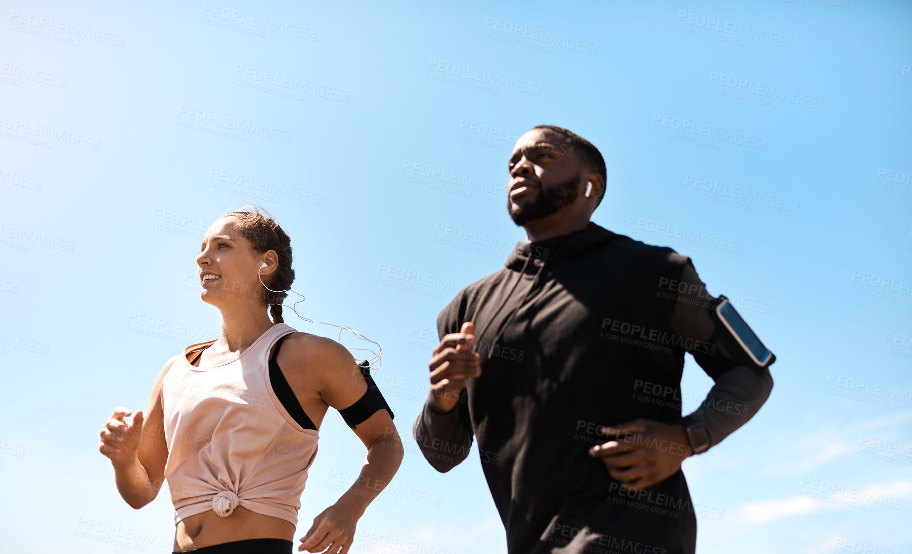 Buy stock photo Shot of two sporty young people out for a run