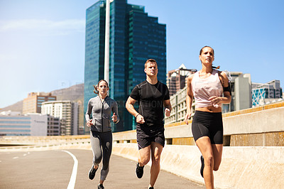 Buy stock photo Shot of a group of sporty young people out exercising together