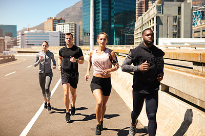 Buy stock photo Shot of a group of sporty young people out exercising together
