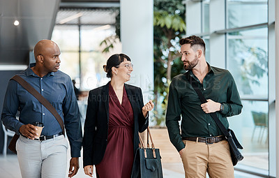 Buy stock photo Cropped shot of three business colleagues talking while walking through their office