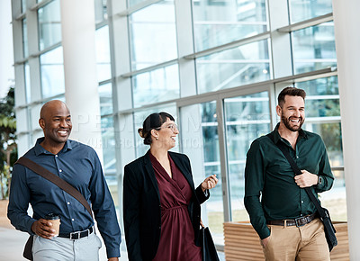 Buy stock photo Cropped shot of three business colleagues talking while walking through their office