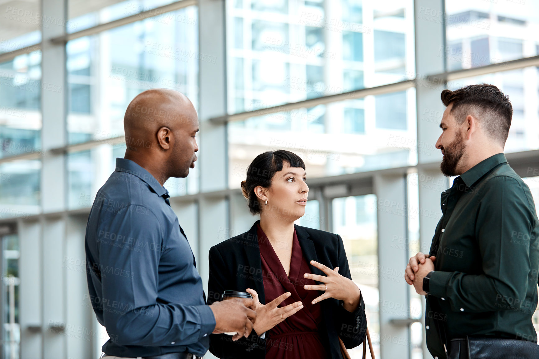 Buy stock photo Cropped shot of three business colleagues talking while standing in their office
