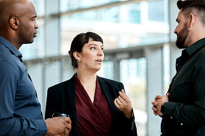 Buy stock photo Cropped shot of three business colleagues talking while standing in their office