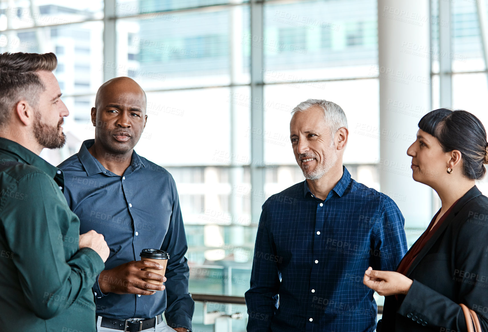 Buy stock photo Cropped shot of four business colleagues talking while standing in their office
