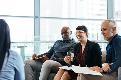 Buy stock photo Cropped shot of four business colleagues talking while sitting in their office
