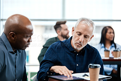 Buy stock photo Cropped shot of two businessmen having in discussion in the office with their colleagues in the background