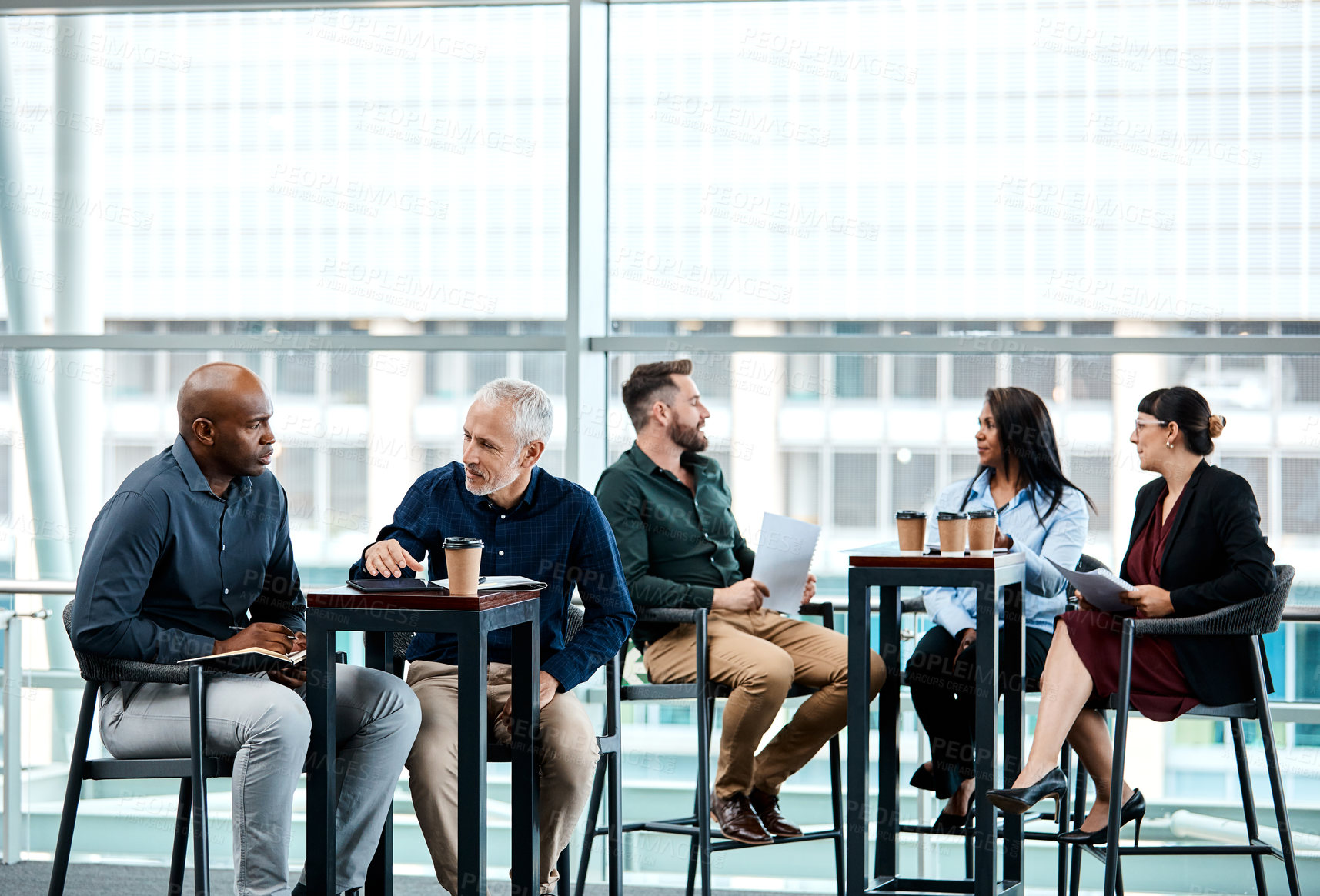 Buy stock photo Cropped shot of two businessmen having in discussion in the office with their colleagues in the background