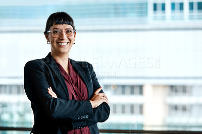 Buy stock photo Cropped portrait of an attractive businesswoman standing with her arms folded in the office