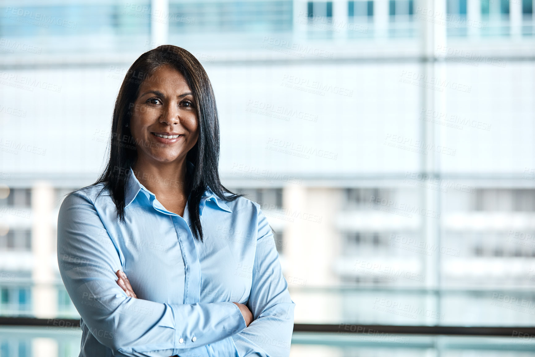 Buy stock photo Cropped portrait of an attractive businesswoman standing with her arms folded in the office