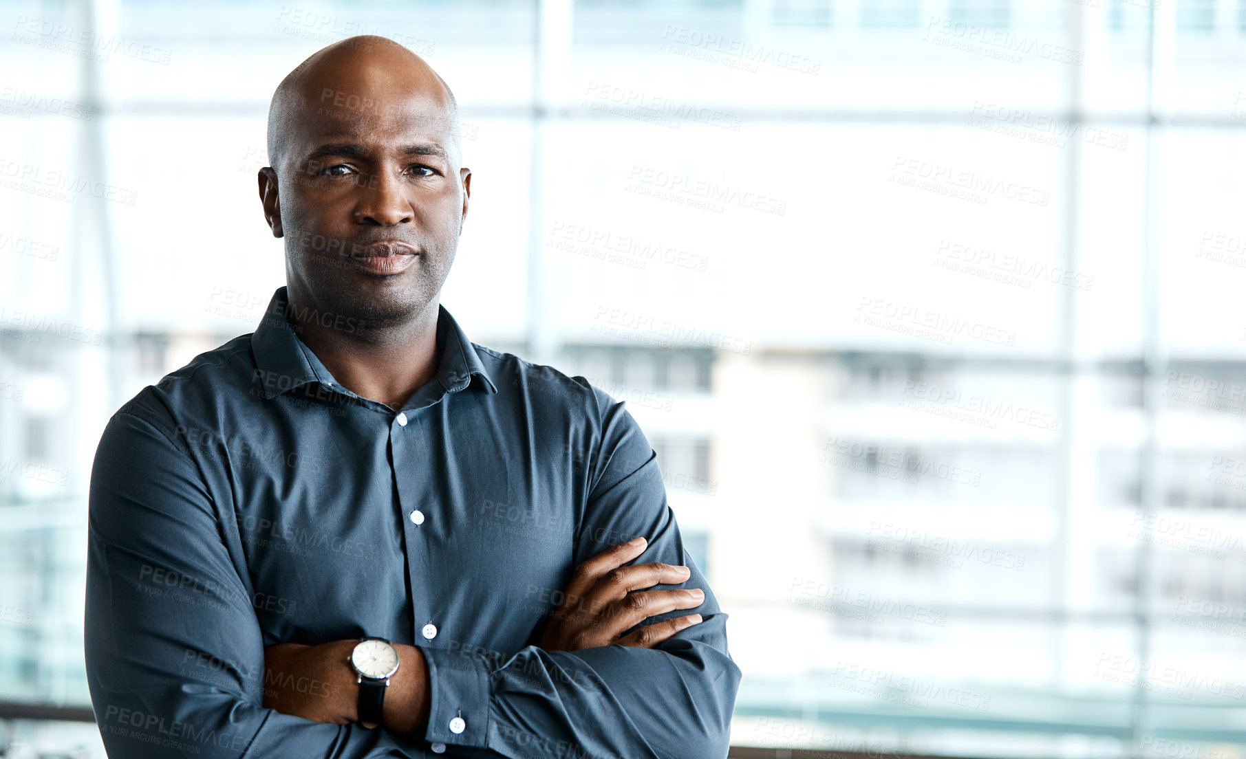 Buy stock photo Cropped portrait of a handsome businessman standing with his arms folded in the office