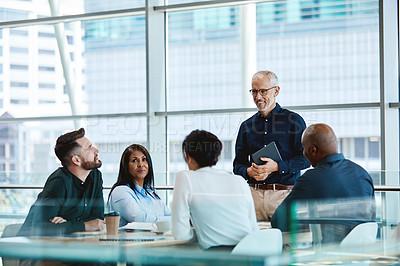 Buy stock photo Shot of a mature businessman smiling during a meeting with colleagues at work