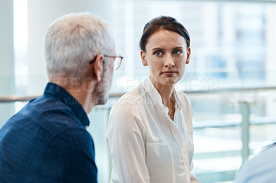Buy stock photo Shot of two businesspeople people having a conversation together during a meeting with colleagues at work