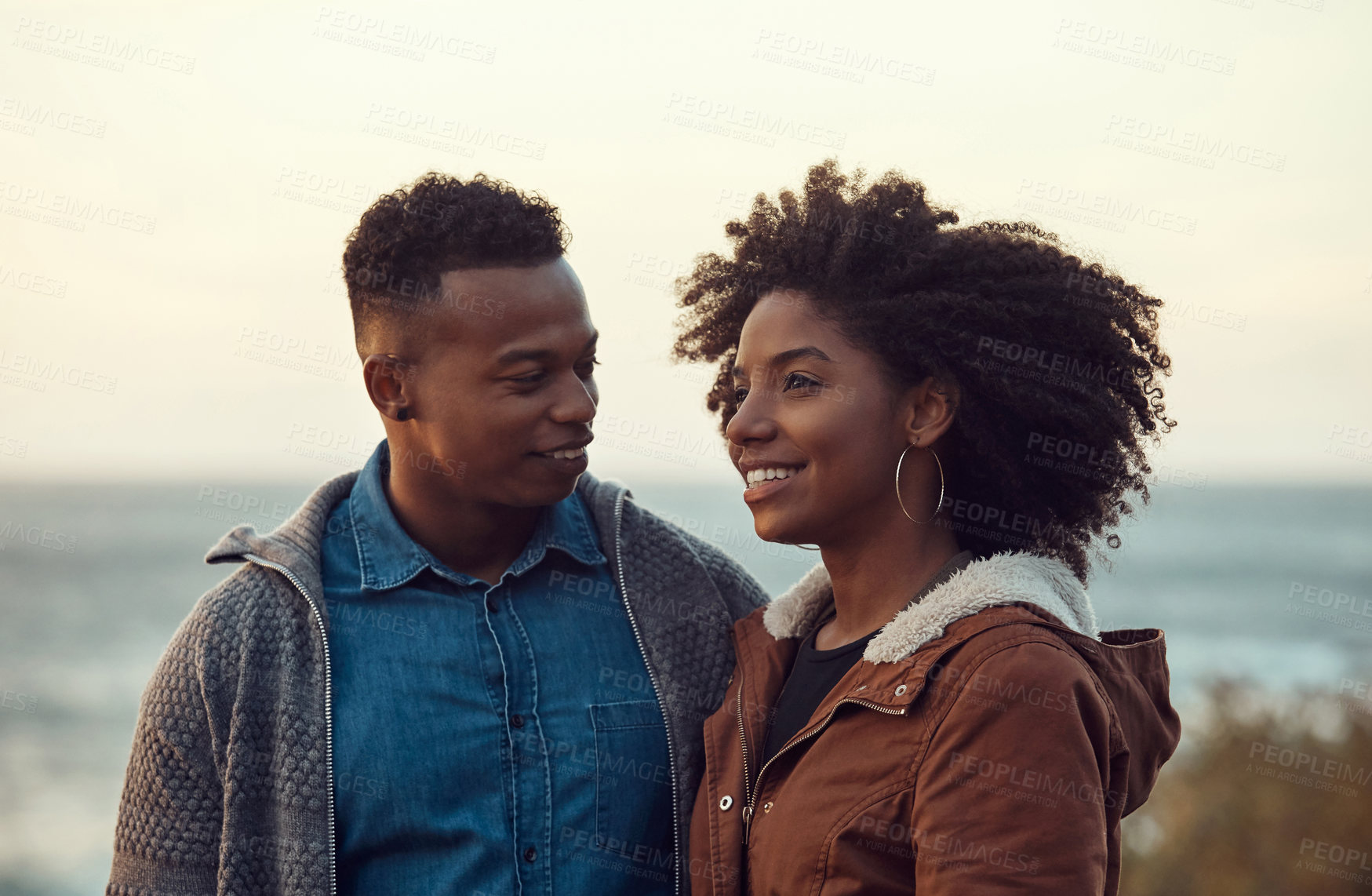 Buy stock photo Love, happy couple or bonding by ocean for connection, trust or holiday with partner together. African woman, man and commitment at beach on vacation, support and care for relationship wellness