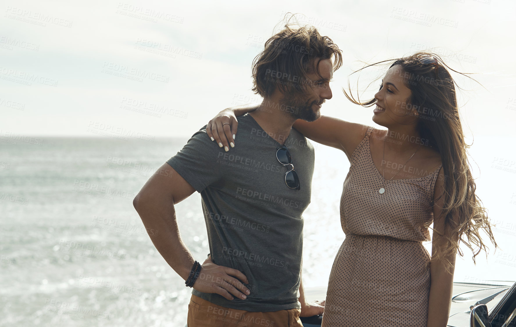 Buy stock photo Love, couple and hug on road trip by sea for connection, smile and bonding on summer holiday. Embrace, happy woman and man at ocean on vacation date by car, travel and care with partner outdoor