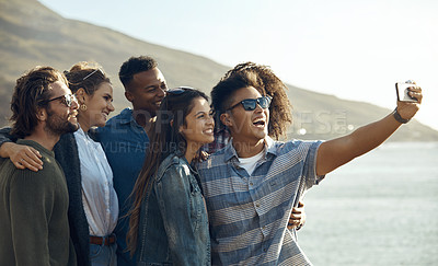 Buy stock photo Cropped shot of a diverse young group of friends posing for a selfie together at the beach during a road trip