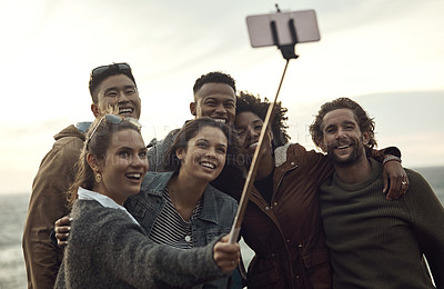 Buy stock photo Cropped shot of a diverse young group of diverse friends posing for a selfie together on the beach