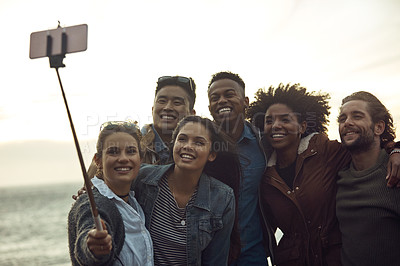 Buy stock photo Cropped shot of a diverse young group of friends posing for a selfie together on the beach during a road trip