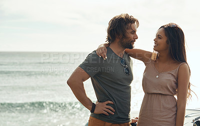 Buy stock photo Cropped shot of an affectionate young couple holding each other and standing together on the beach during a road trip