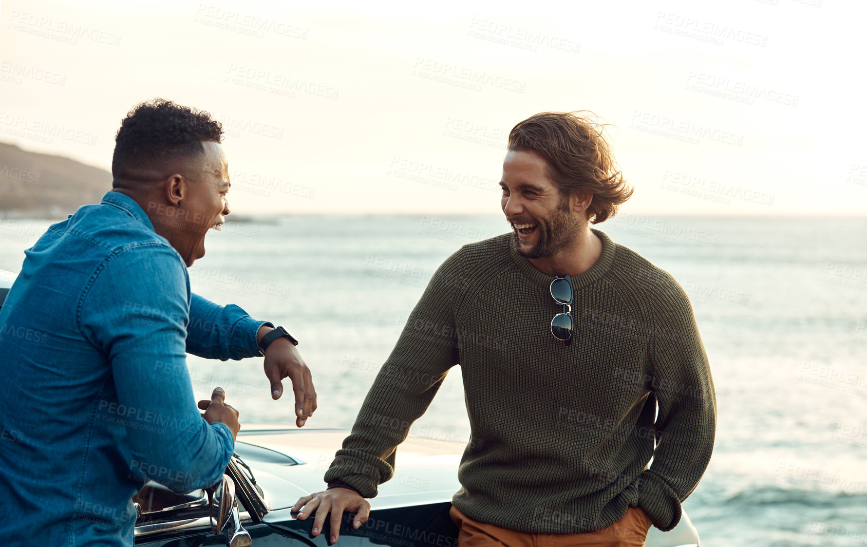 Buy stock photo Cropped shot of two handsome young men greeting each other at the beach during a road trip