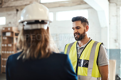 Buy stock photo Cropped shot of a handsome young male warehouse worker talking to his supervisor