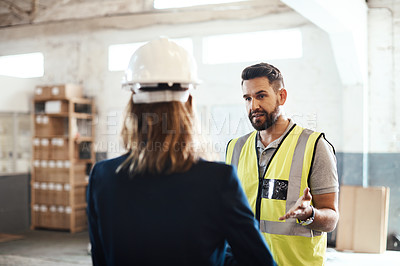 Buy stock photo Cropped shot of a handsome young male warehouse worker talking to his supervisor